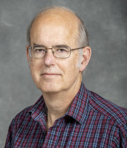 Balding man in plaid shirt an glasses