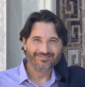 head and shoulders of smiling caucasian man with brown hair, brown eyes, and a salt-and-pepper beard