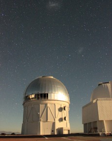 The Víctor M. Blanco Telescope at the Cerro Tololo Inter-American Observatory in Chile, where the Dark Energy Camera is being used to collect image data for the DECam Legacy Survey. The glint off the dome is moonlight; the small and large Magellanic clouds can be seen in the background. Image: Dustin Lang, University of Toronto